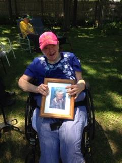 A woman holds Helen's picture at a celebration in Helen's honor.